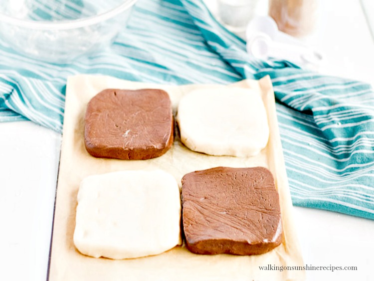 Vanilla and chocolate dough squares wrapped in plastic wrap. 