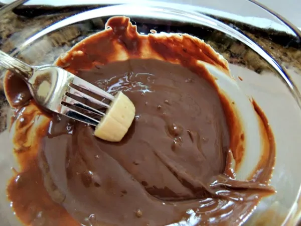 Dip sliced bananas into melted chocolate and peanut butter mixture. 