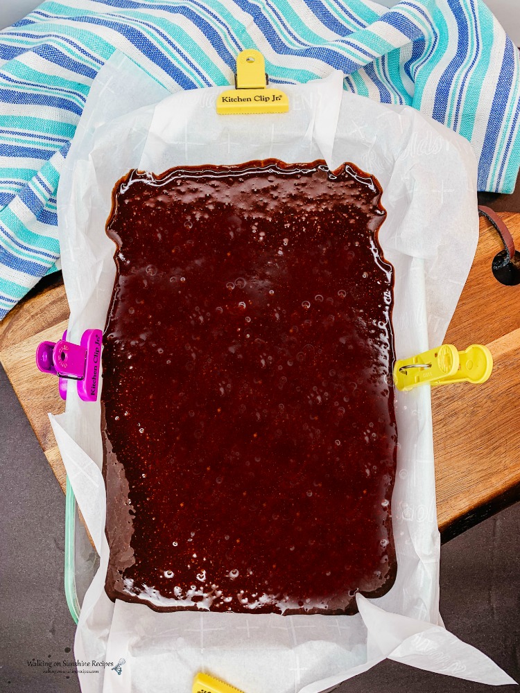 brownie batter in baking dish lined with parchment paper before baking. 