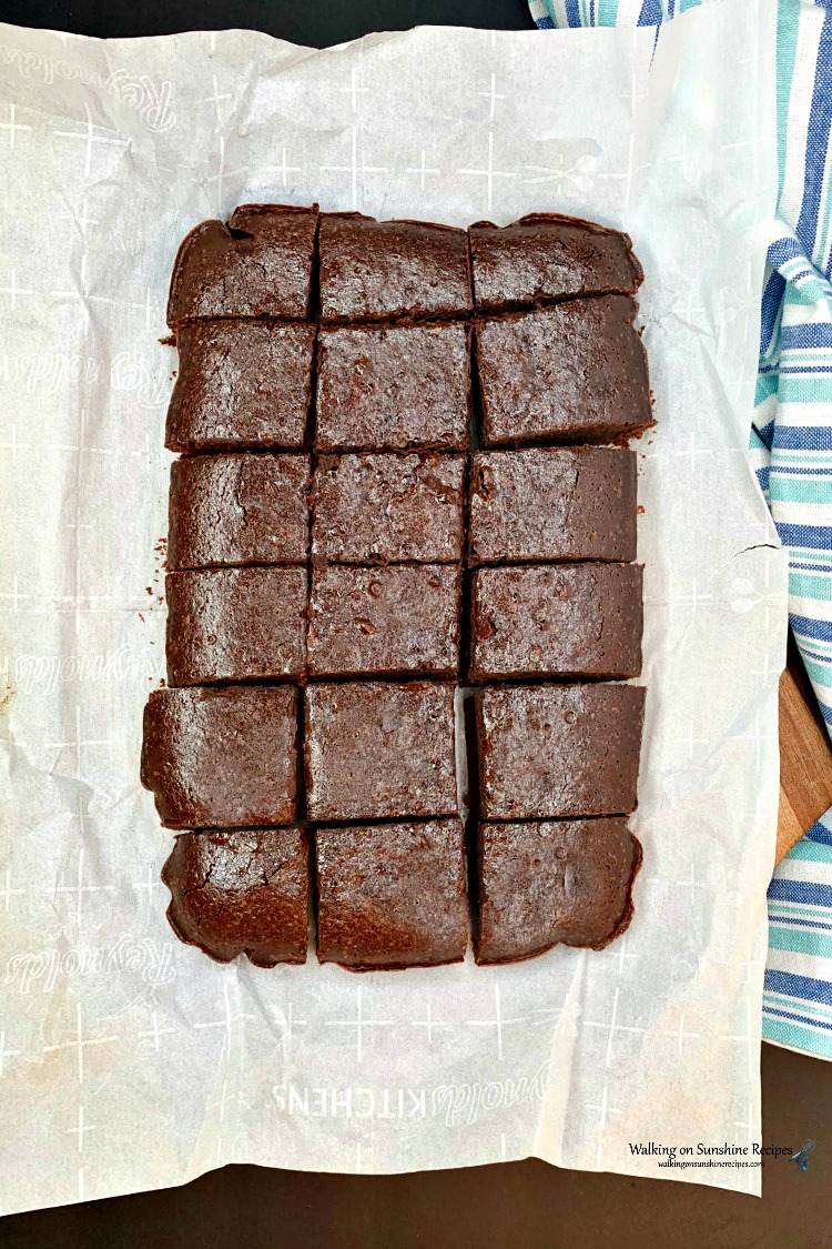 https://walkingonsunshinerecipes.com/wp-content/uploads/2012/11/Homemade-Brownies-made-with-coffee-in-the-batter-sliced-with-plastic-knife-on-cutting-board-with-parchment-paper.jpg