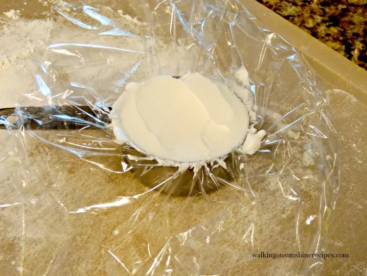 Add shortening to measuring cup with plastic wrap inside.