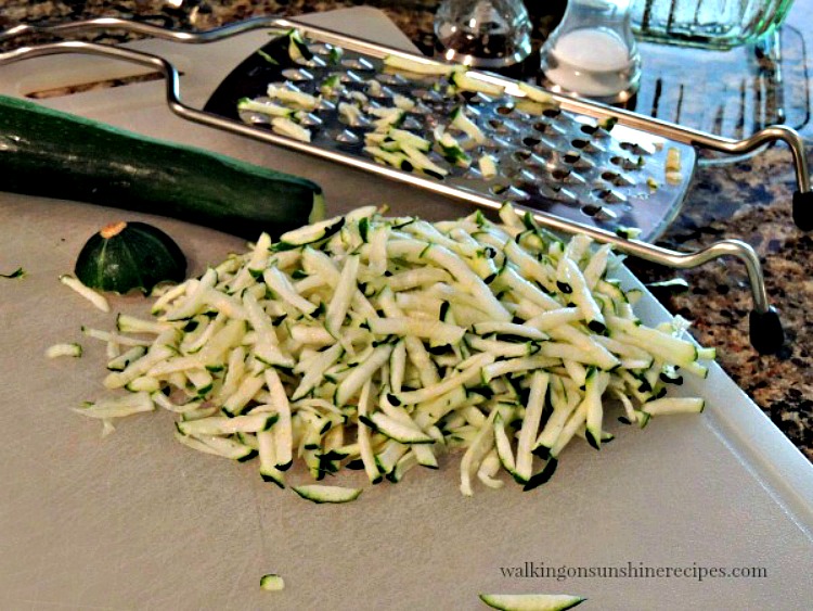 Grated Zucchini on cutting board from Walking on Sunshine Recipes