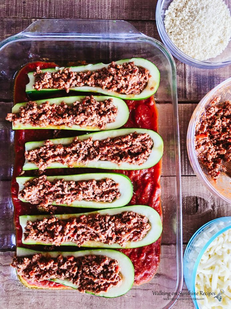 Add ground beef to the hollowed out Zucchini in baking dish