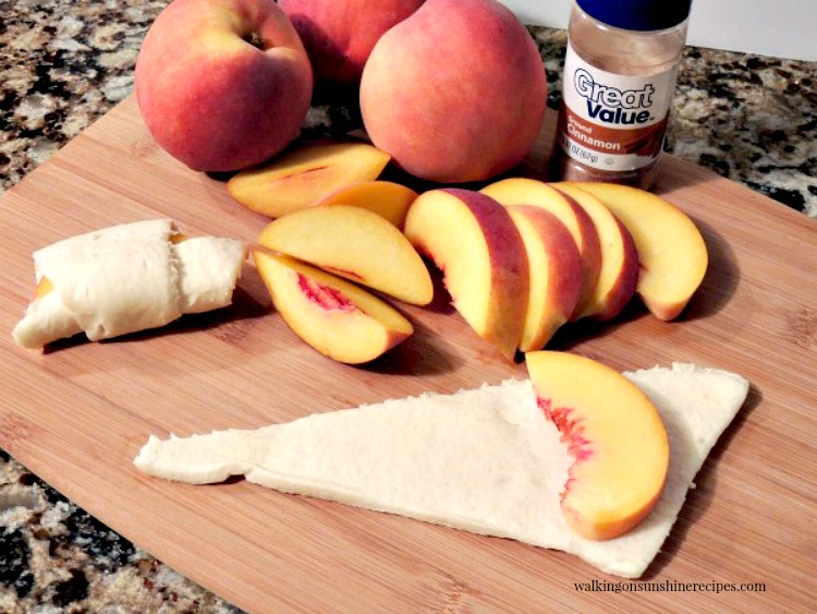 Lay peach slices on top of crescent roll dough for Peach Dumplings. 