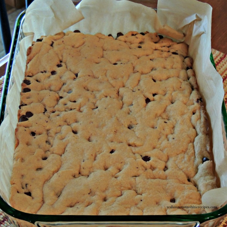 Chocolate Chip Cookie Bars in baking dish with parchment paper.