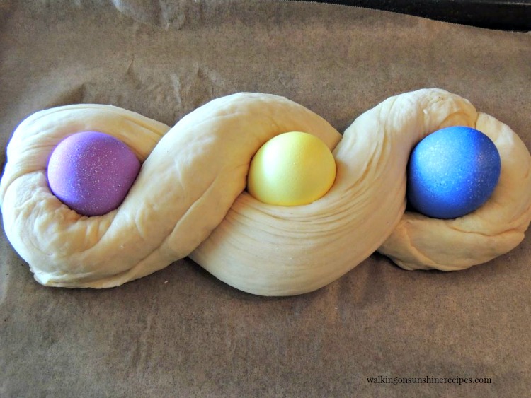 Italian Easter Bread with 3 colored eggs on baking pan not baked