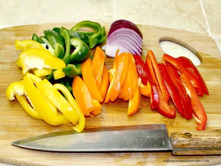 Yellow, Red, Green and Orange Peppers sliced on cutting board for Easy Steak Fajitas