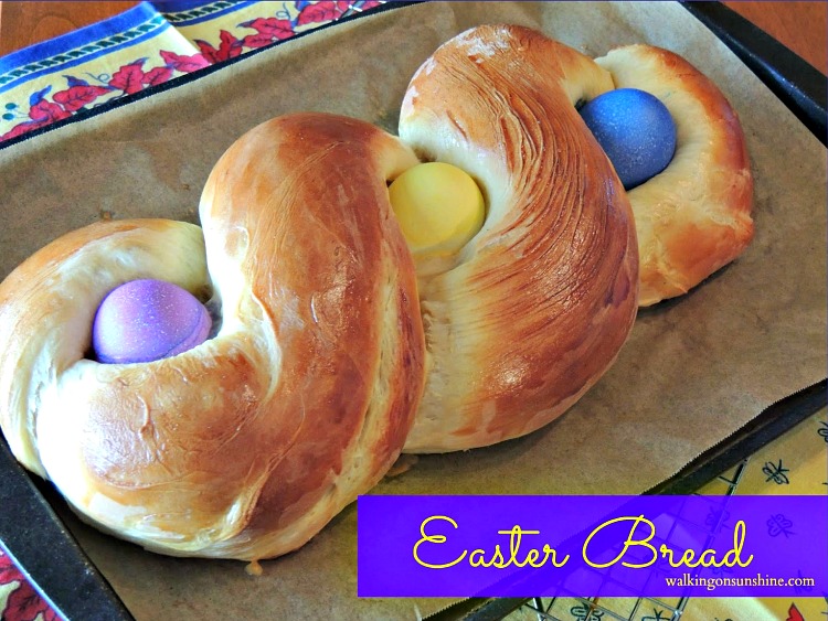 Italian Easter Bread with colored eggs on parchment paper baking tray. 