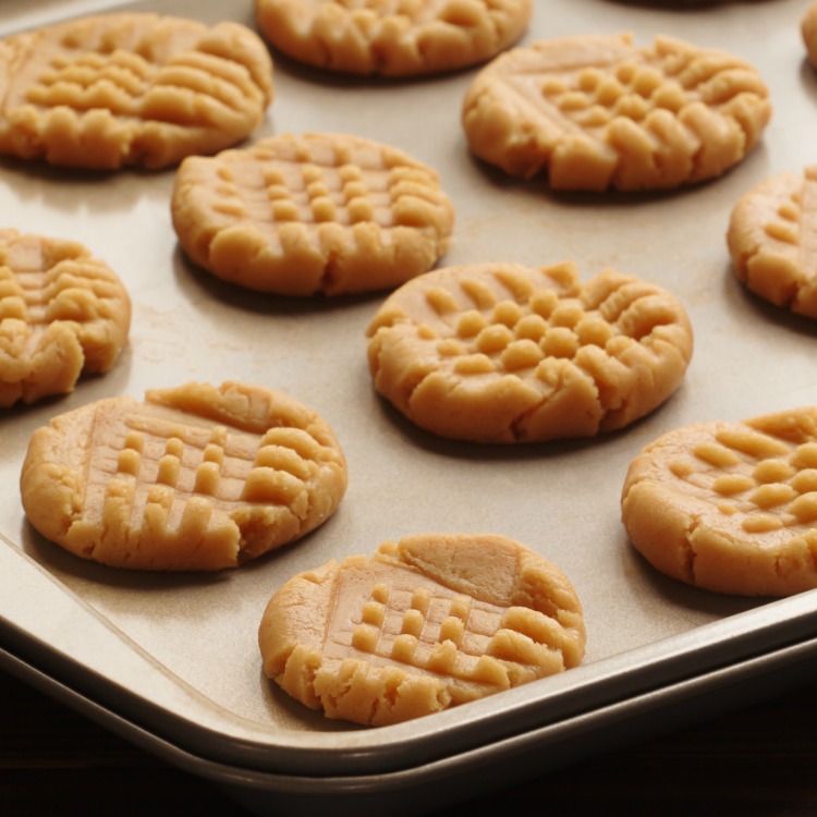 peanut butter cake mix cookies unbaked on a baking sheet lined with parchment paper. 