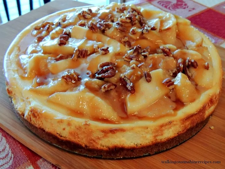 Cheesecake with Caramel Apple Topping on cutting board. 