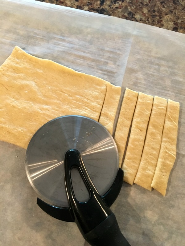 With the excess dough, cut strips that will become the stripes for the candy cane danish. 