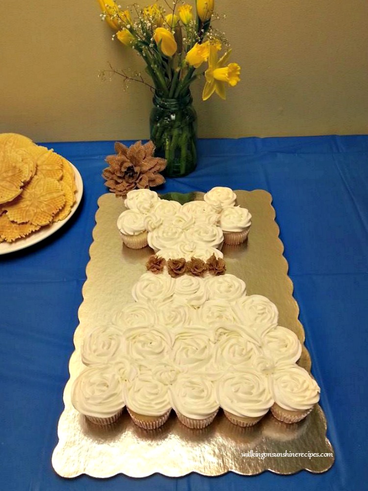 Cupcakes in the shape of a wedding dress on serving tray. 
