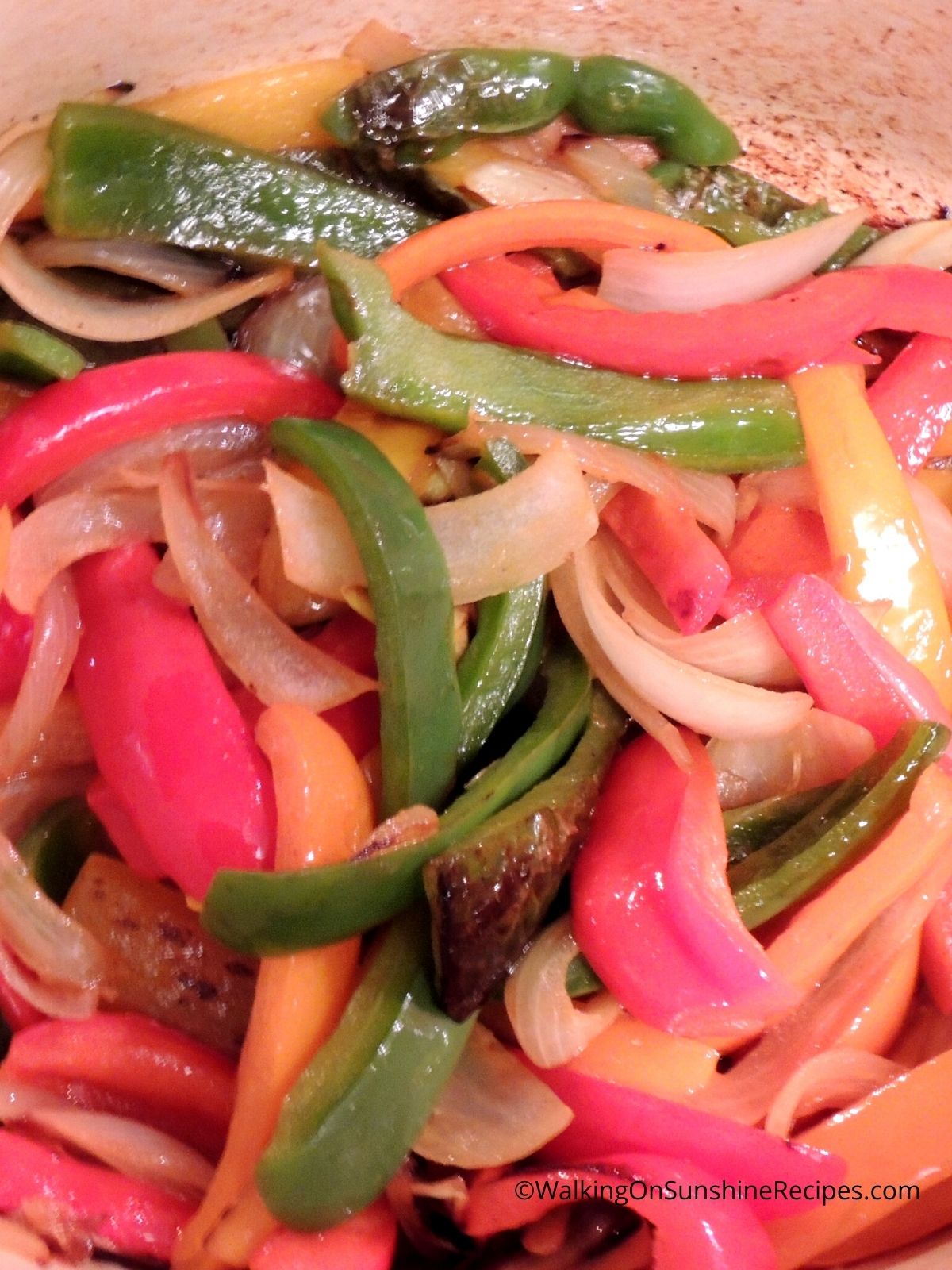 Peppers onions in cast iron pan.