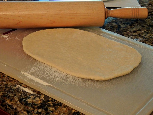 Rolling out the pizza dough to make homemade bread sticks. 
