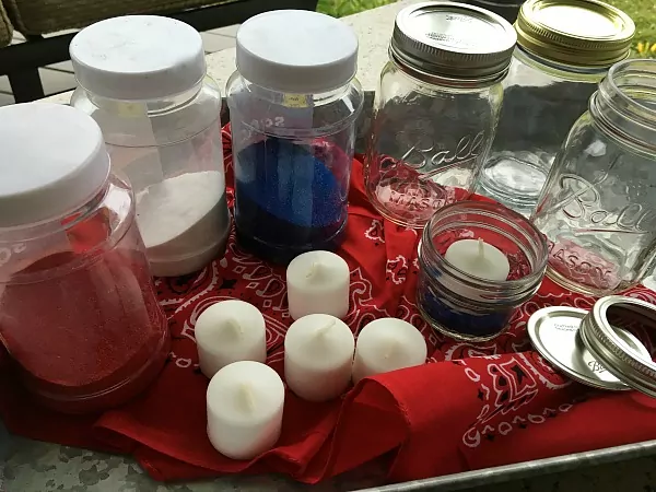 Here's what you need for the project: colored sand, mason jars and candles. 