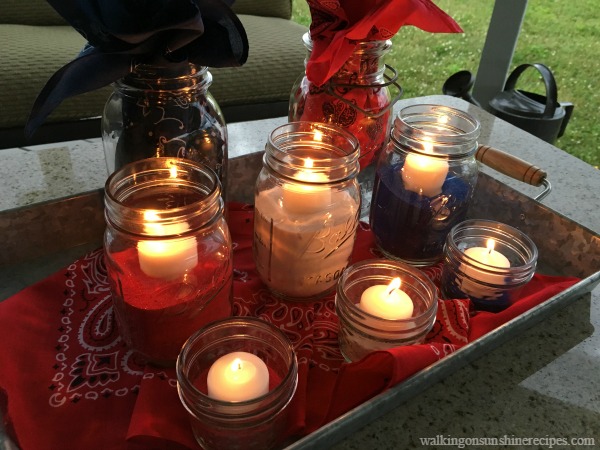 Mason Jar Patriotic Table Centerpiece with mason jars, colored sand and candles. 