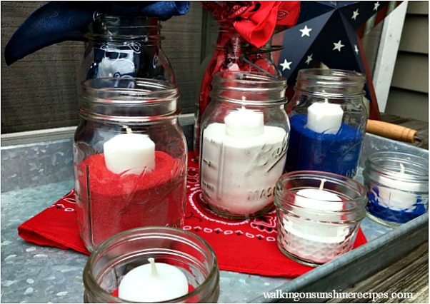 Mason Jar Patriotic Table Centerpiece with mason jars, colored sand and candles. 