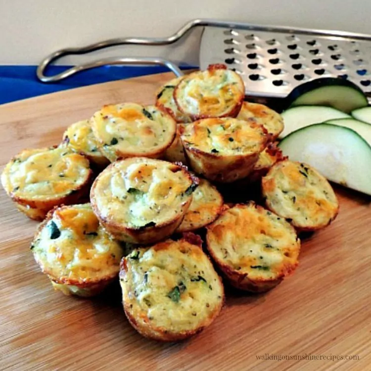 Zucchini Puffs on wooden board with cheese grater. 