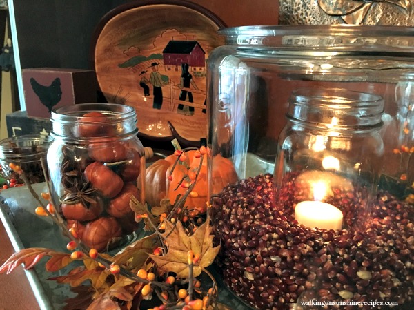 Close up of the glass jars filled with pumpkins and kernels decorated for Fall from Walking on Sunshine.