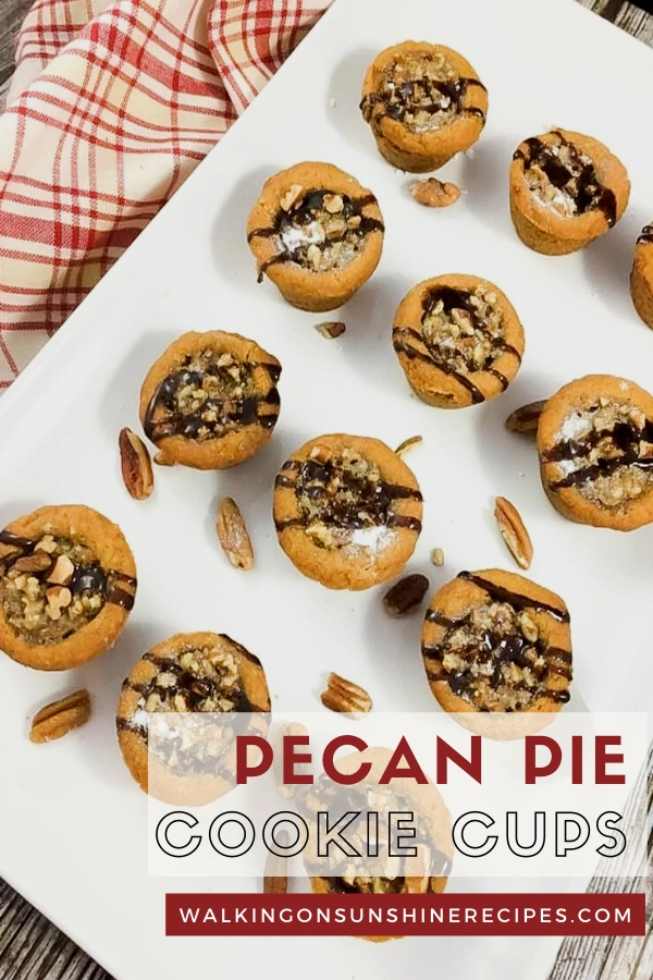 Pecan Pie Cookie Cups on white tray drizzled with chocolate syrup. 