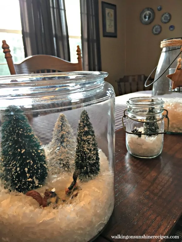 Glass jar terrariums with pine branches make a beautiful centerpiece for Christmas from Walking on Sunshine. 