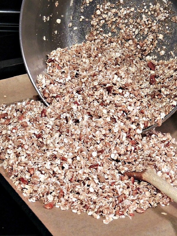 Spread homemade granola on baking tray spread with parchment paper before baking. 