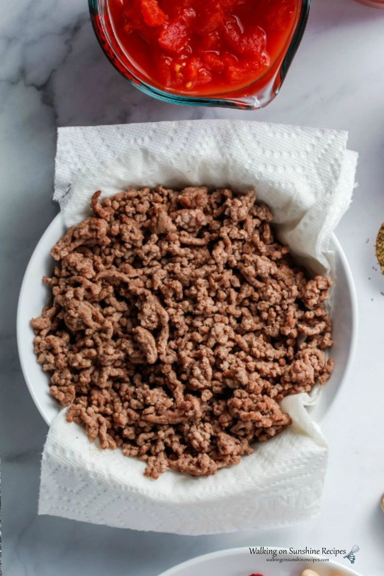 Browned Ground Beef draining in colander with paper towels. 