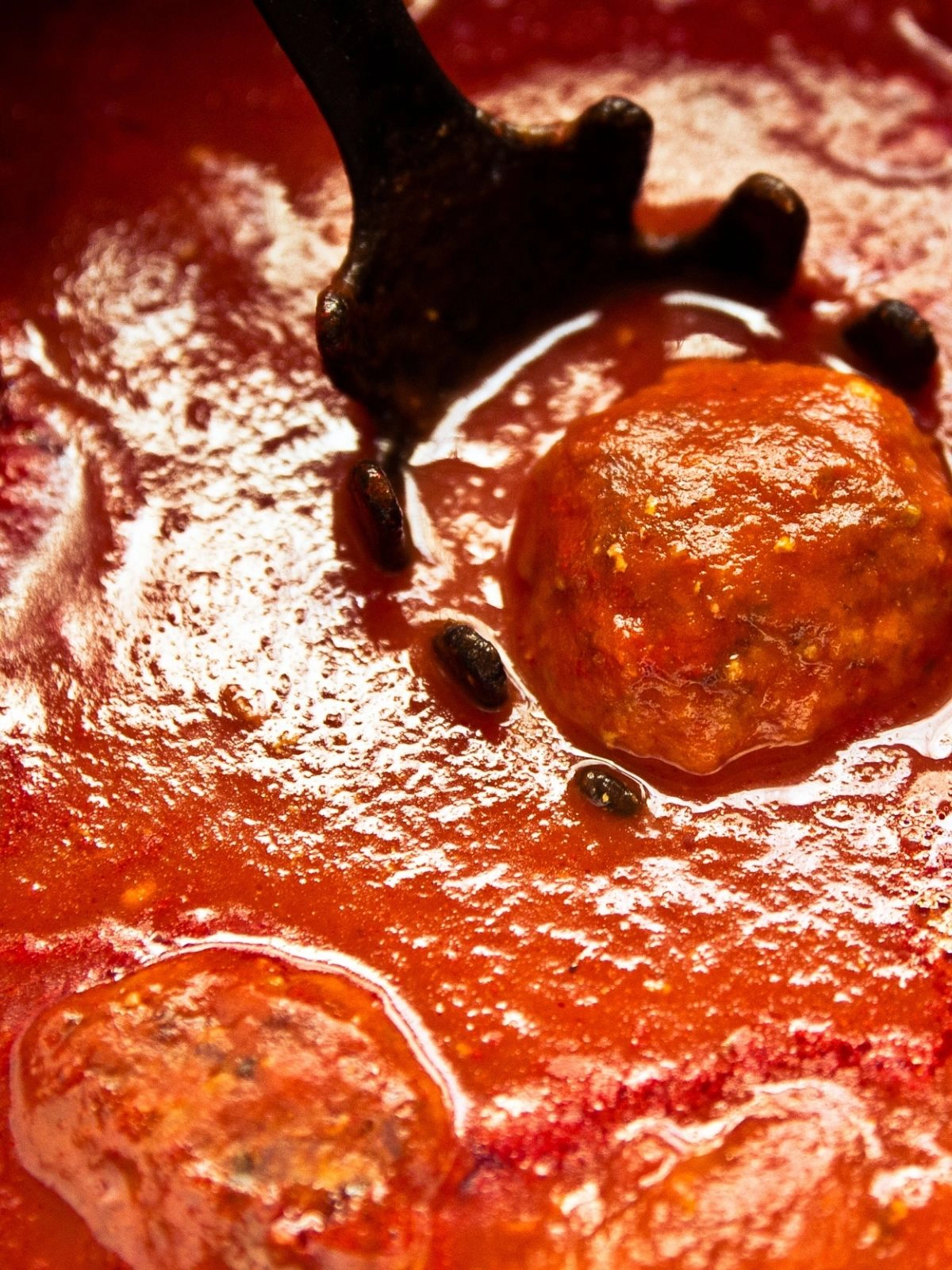 Closeup of meatball in sauce.