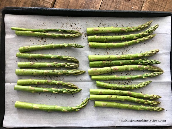 Place asparagus on a parchment lined baking tray from Walking on Sunshine