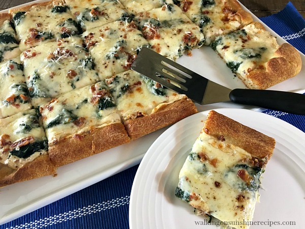 Spinach Alfredo Bacon Pizza served on white plate from Walking on Sunshine