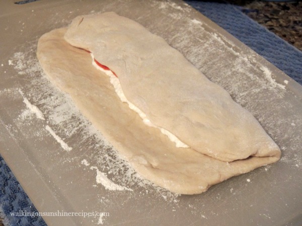 Fold one side of the pizza dough over the ricotta and pepperoni.