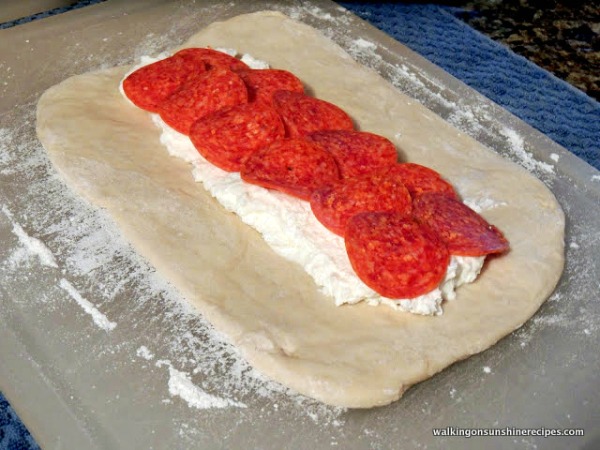 Pizza dough with ricotta cheese and pepperoni.