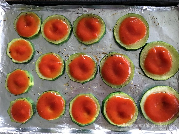 Add a little marinara sauce to the tops of each zucchini round.