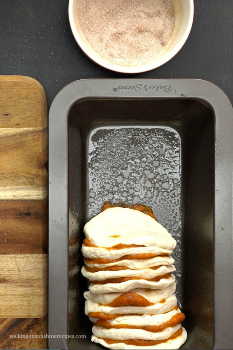 Add the biscuits to the loaf pan for Pumpkin Spice Pull Apart Bread. 