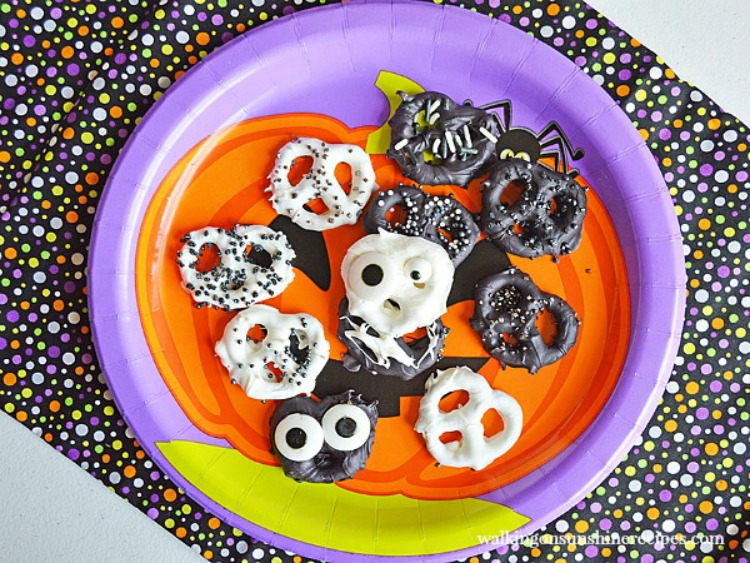 Halloween met chocolade bedekte Pretzels op pompoenplaat