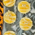 Mummy Quesadillas on a marble serving platter and halloween decor around them.