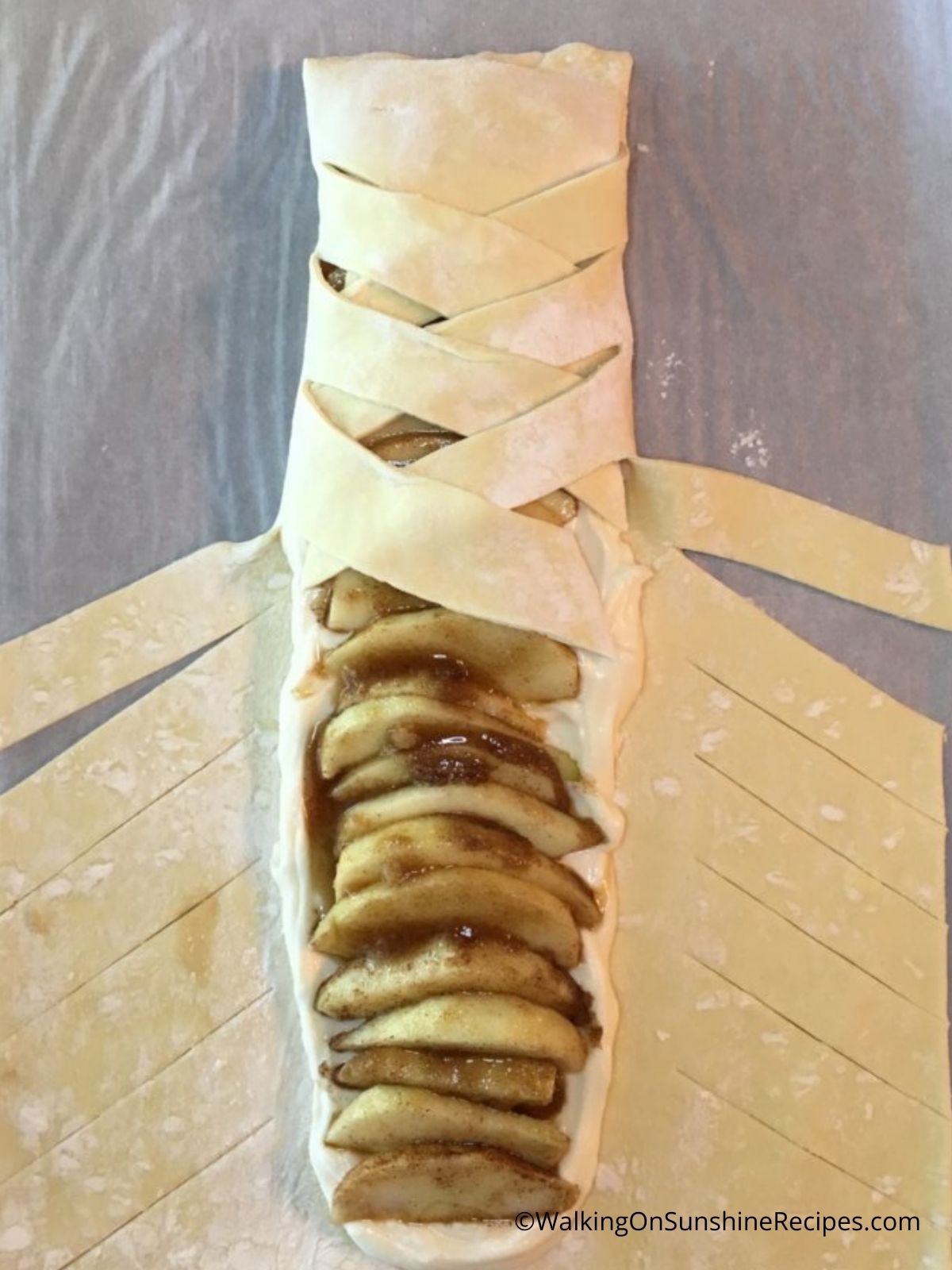 Wrap puff pastry around apple slices.