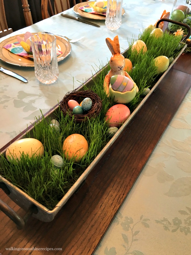 Grass Centerpiece filled with wooden and plastic eggs and ceramic bunny. 
