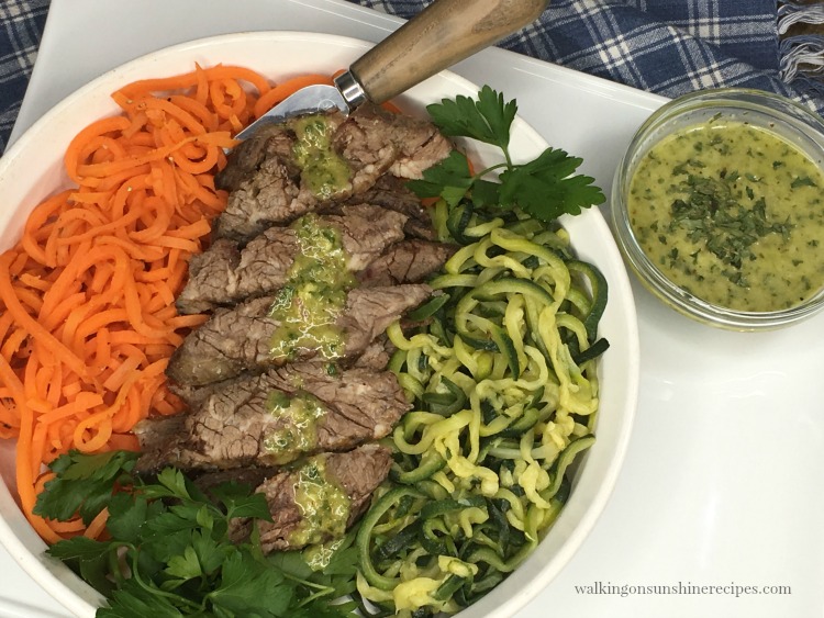 Zucchini and Carrot Spirals served with grilled steak in a white dish. 