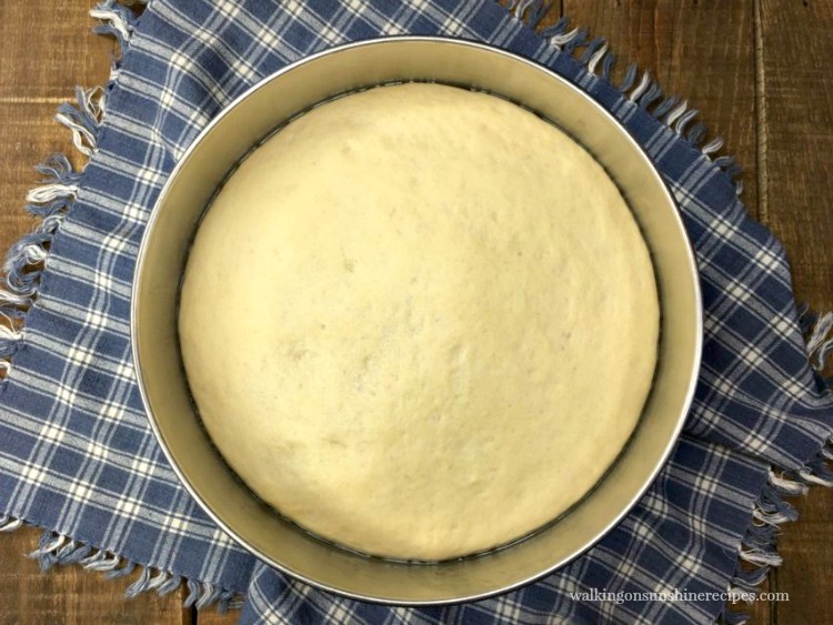 pizza dough made with beer after first rise in metal bowl.