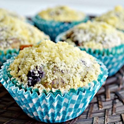 Blueberry Muffins with Streussel Topping on brown bread board from Walking on Sunshine Recipes