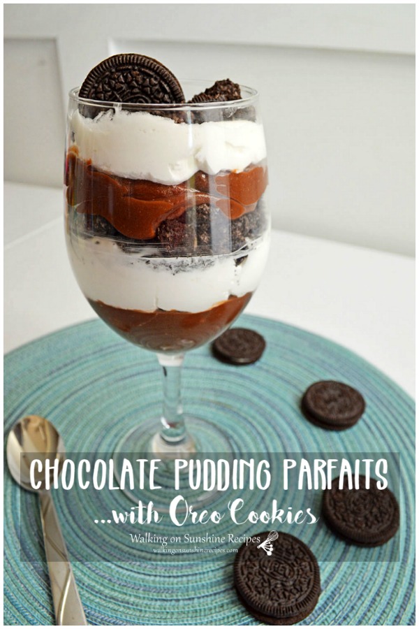Chocolate Pudding Parfaits in glass stemware with chocolate sandwich cookies on blue placemat. 