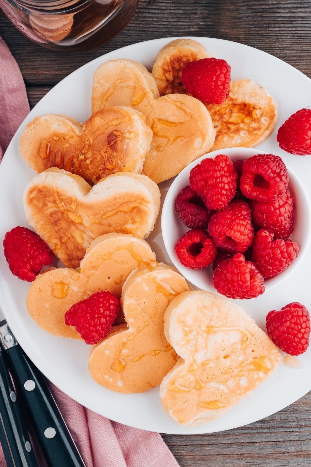 Heart shaped pancakes on white plate.