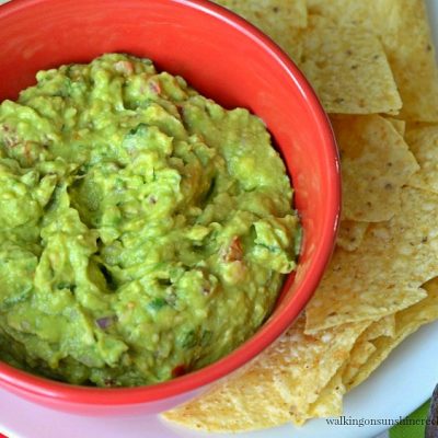 Homemade Guacamole in red bowl with chips from Walking on Sunshine Recipes