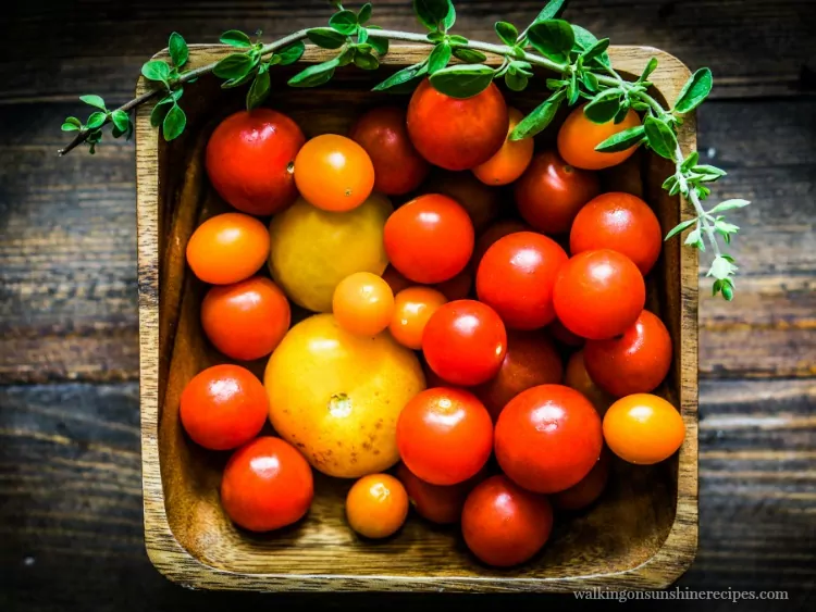 Tomatoes in Wooden Basket with sprig of herbs on top from Walking on Sunshine Recipes