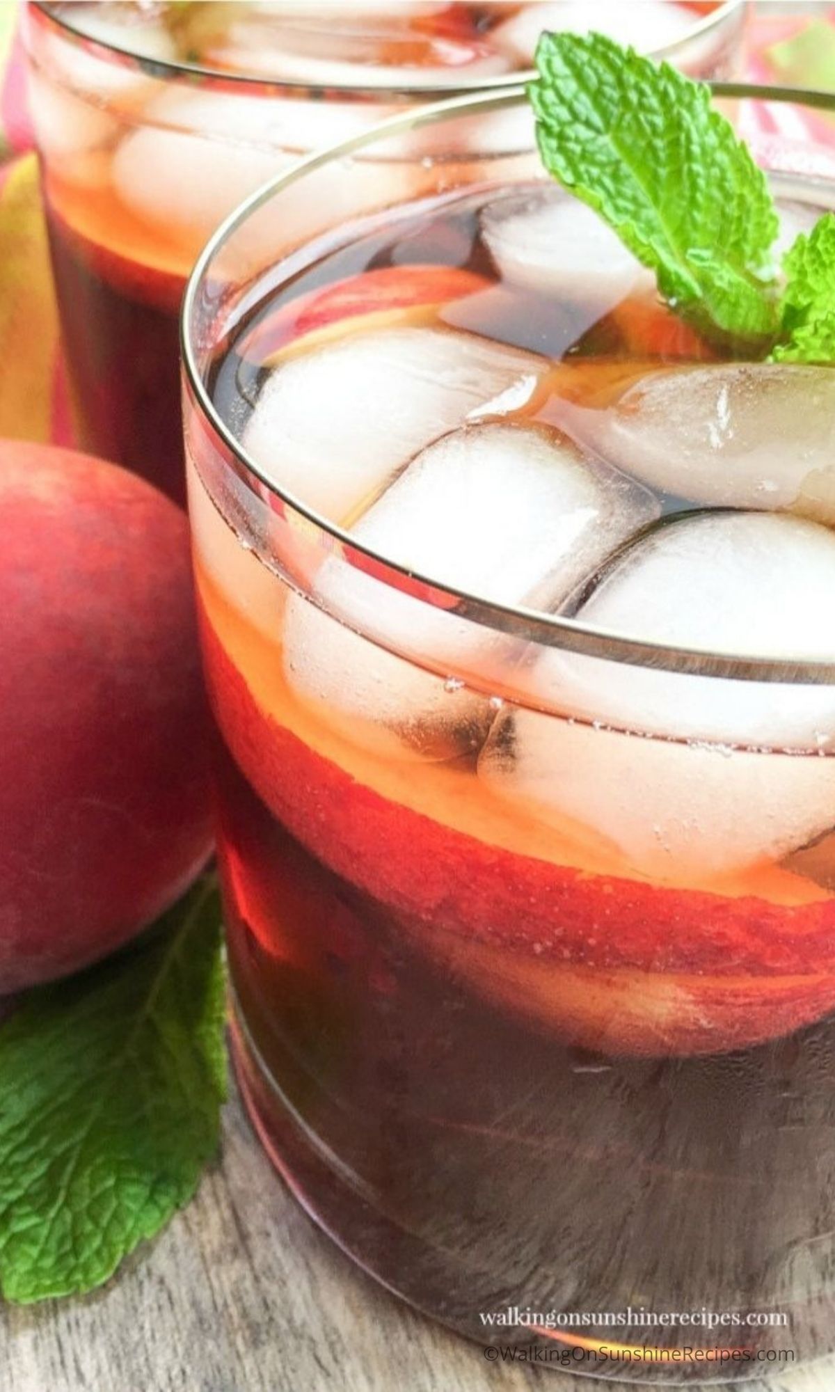 glass with peach tea, ice and sprig of mint. 