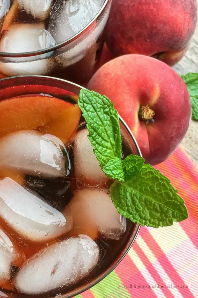 Peach Iced Tea in glass with fresh sprig of mint. 