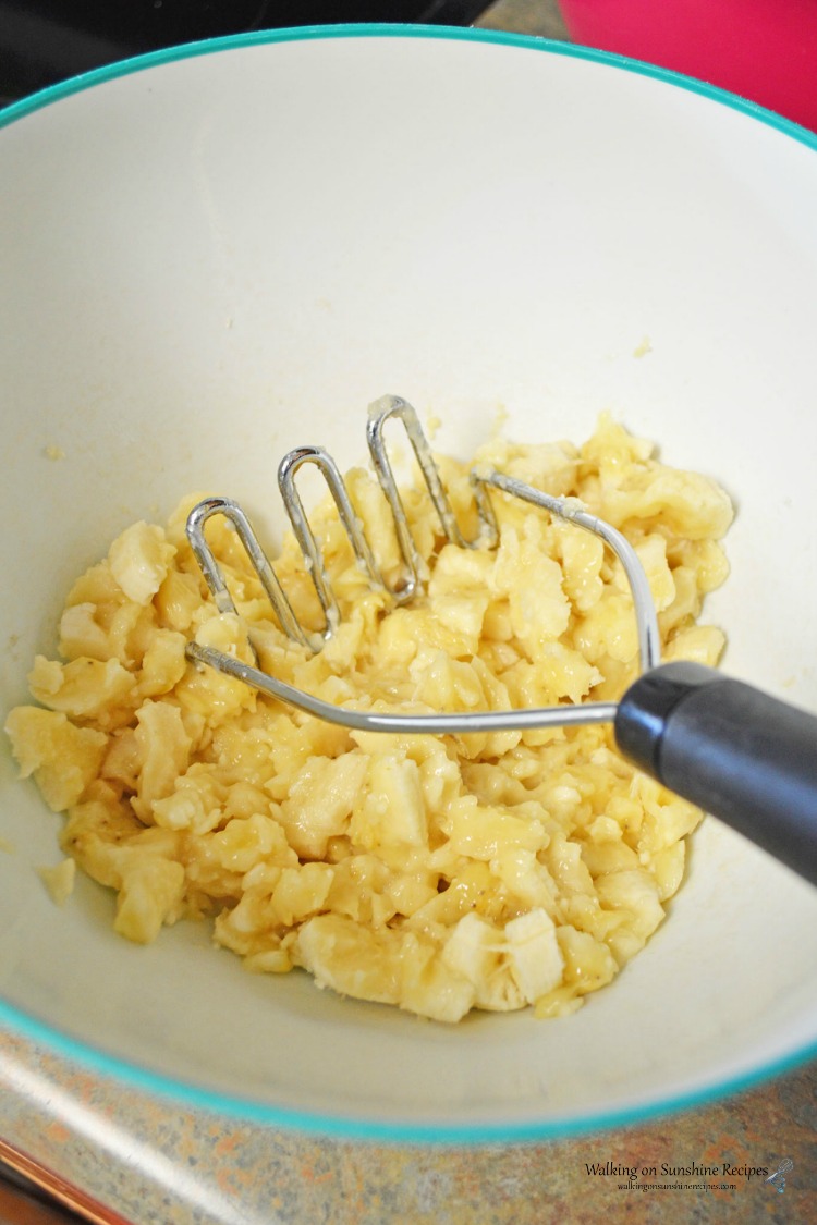 Mashing bananas with potato masher for banana bread. 