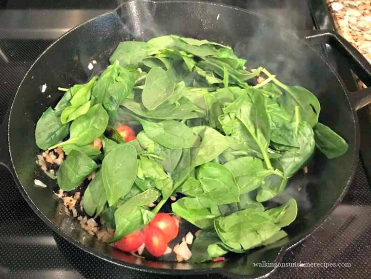 Add fresh spinach to the cast iron pan.