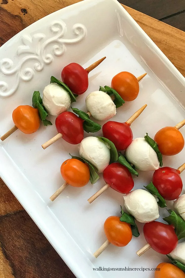 Arrange the cherry tomatoes, basil leaves and mozzarella balls on a short bamboo skewer. 